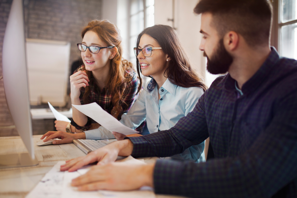 Group of people at a conference table, in business professional clothes, having a conversation