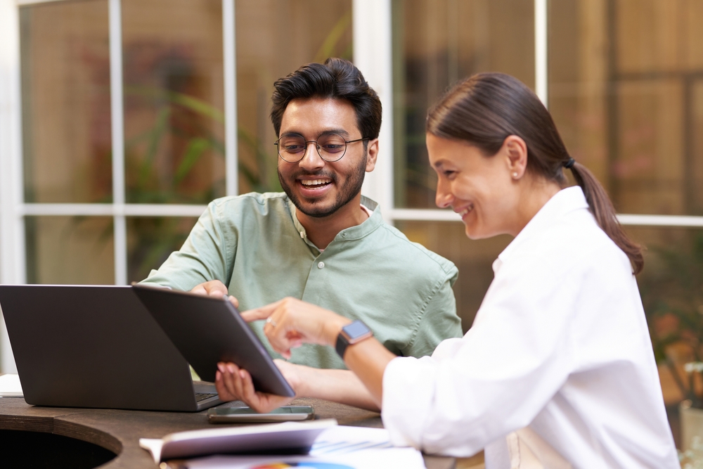 image of two professionals smiling and looking at a computer.