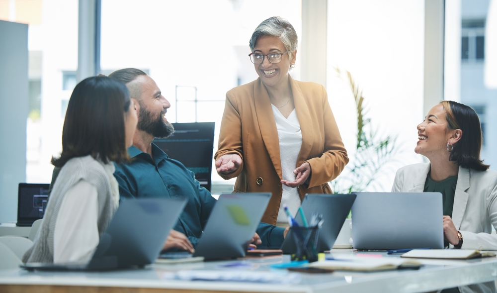 business professionals looking at a laptop and smiling.