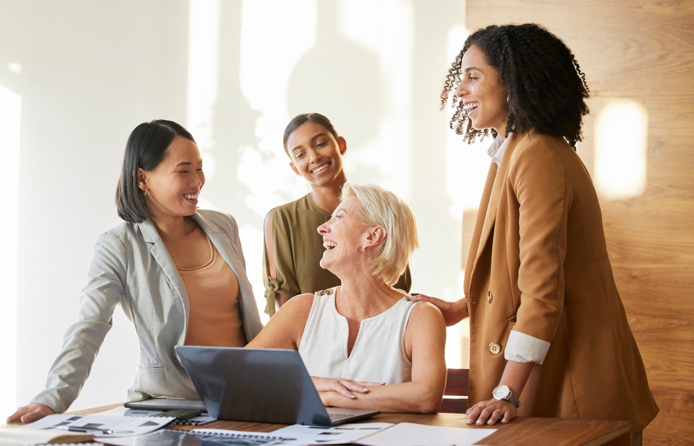 business professionals looking at a laptop and smiling.