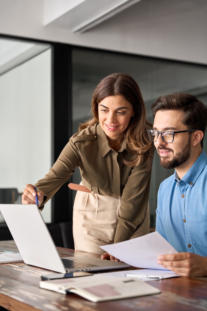 business professionals looking at a laptop and smiling.